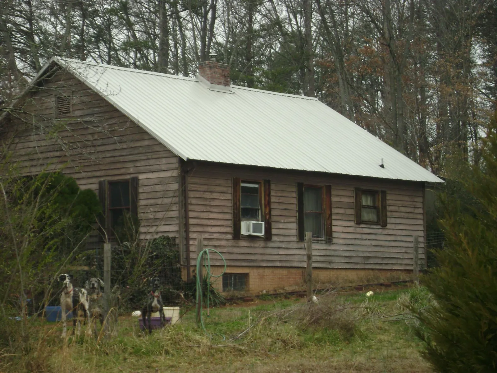 White metal roof on an old wood sided farmhouse, from a Metal Roof Installation job in Oakley